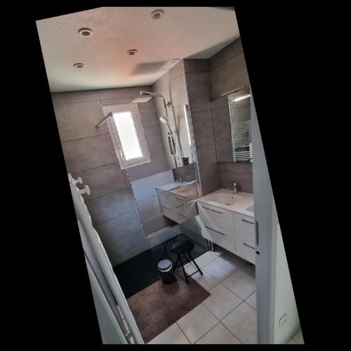 une salle de bain avec un lavabo et un miroir dans l'établissement Maison de vacances Torreilles plage 6 personnes, à Torreilles