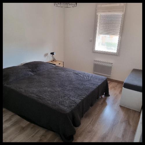 une chambre avec un lit noir et une fenêtre dans l'établissement Maison de vacances Torreilles plage 6 personnes, à Torreilles