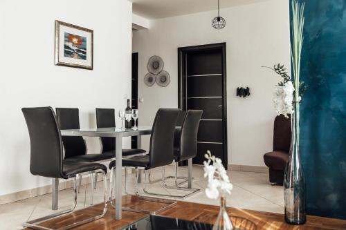 a dining room with a table and black chairs at Villa Lidija in Omiš
