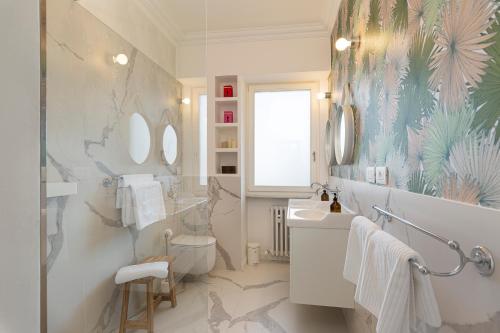 a bathroom with a toilet and a sink and mirrors at Lago 270 in Stresa