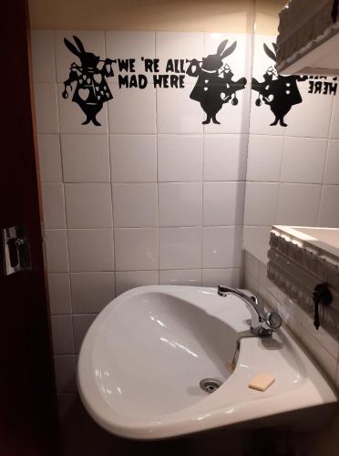 a bathroom sink with stickers on the wall at Guesthouse Gate5 in Anadia