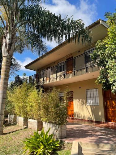 a building with a palm tree in front of it at Departamentos Campitelli in General Pacheco