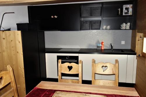 a kitchen with a stove and a table and chairs at Chalet des Alpes NATURE & MOUNTAIN by Alpvision Résidences in Prarion