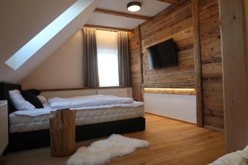 a bedroom with two beds and a flat screen tv at Chalupa pod Ořechem in Rokytnice nad Jizerou