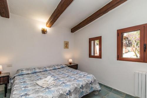1 dormitorio con cama y ventana en Appartamento Colomba, en Capo Testa