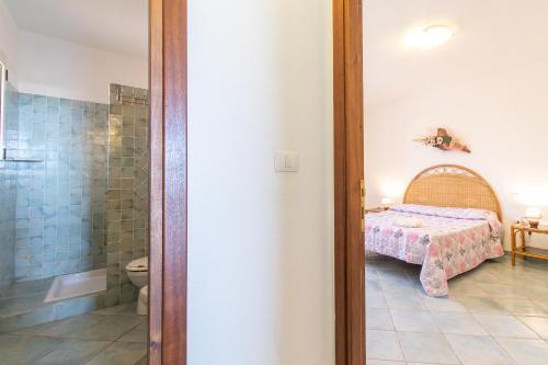 1 dormitorio con 1 cama y baño con ducha en Elisa Vista Mare en Capo Testa
