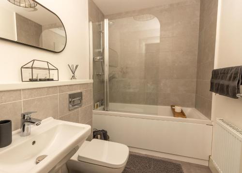 a bathroom with a sink and a toilet and a bath tub at Arranmore House in Auchterarder