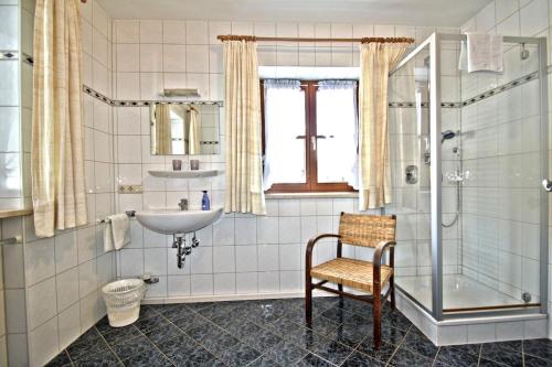 uma casa de banho com um lavatório e um chuveiro em Ferienwohnungen Wanderparadies em Aschau im Chiemgau