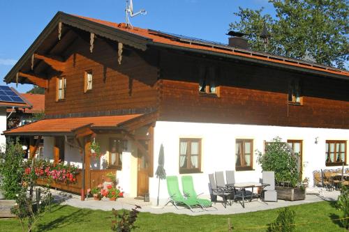 a house with chairs and a table in front of it at Ferienwohnungen Wanderparadies in Aschau im Chiemgau