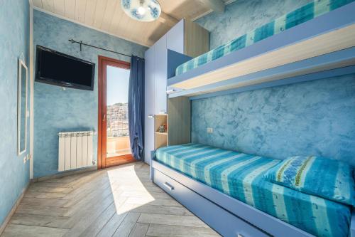 a bedroom with a bunk bed with blue walls at Luxury Apartment Simius in Villasimius