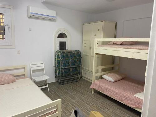 a room with two bunk beds in a room at Big Chalet with Pool & Garden at Marina 4 in El Alamein