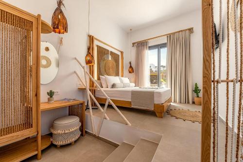 a bedroom with a bed and a window at Le Palme Mykonos in Klouvas