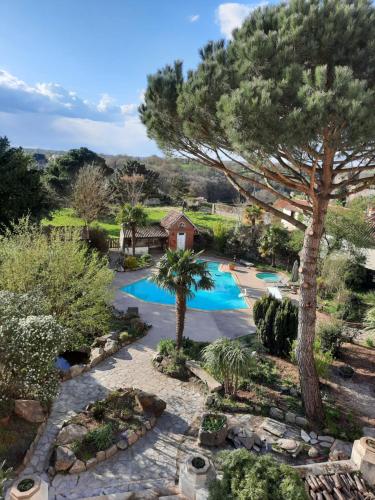 - une vue aérienne sur la piscine dans le jardin dans l'établissement Hôtel De La Barbacane, à Tiffauges