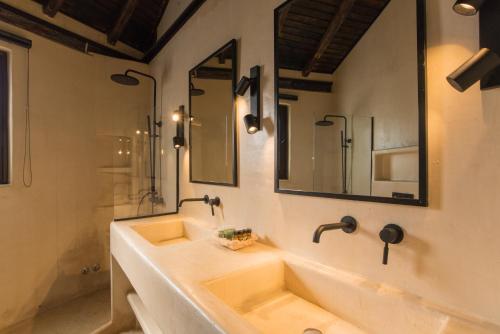 a bathroom with two sinks and two mirrors at Villa Merilen in Develíkia