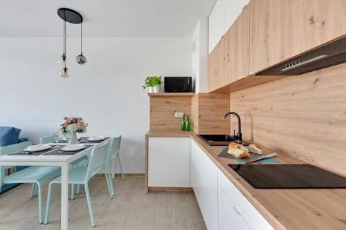 a kitchen with a table and a counter top at BURSZTYNOVA Apartamenty Piamola in Kąty Rybackie