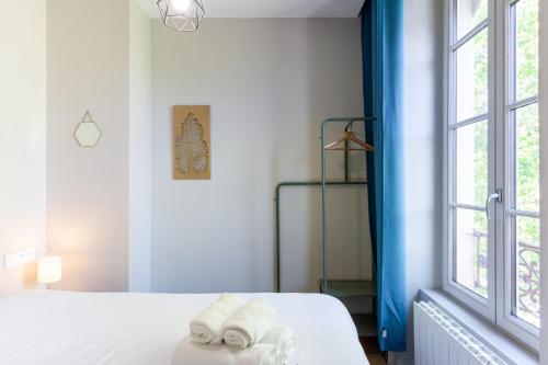 une chambre blanche avec un lit et une fenêtre dans l'établissement Ruby, à Lyon