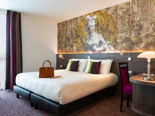 プレジールにあるHôtel Roi Soleil Prestige Plaisirの大きなベッドと壁に絵画が備わるホテルルームです。