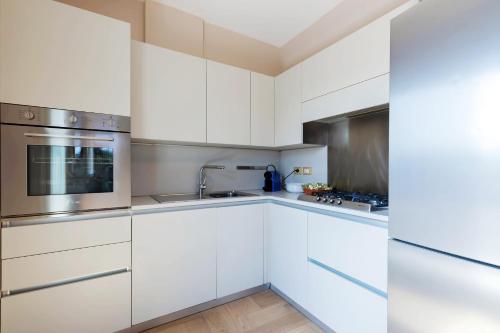 a kitchen with white cabinets and stainless steel appliances at Milan Retreats in Milan