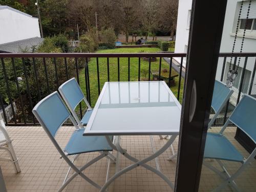 d'une table blanche et de deux chaises sur un balcon. dans l'établissement 20ml du port, au Pouliguen