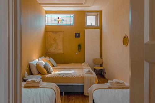 a small room with two beds and a window at Gunnery's Guest House in Alkmaar