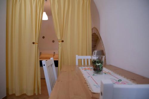 comedor con mesa y cortina amarilla en CASA VACANZE SANTA CROCE en Noci