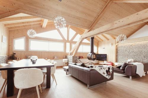 un salon avec un plafond en bois et une table dans l'établissement Chalet Kabane, NEUF, pied des pistes et garage, à Montgenèvre