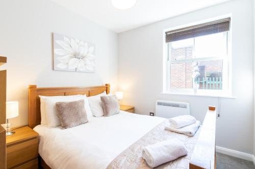 a white bedroom with a bed and a window at Velvet 2-bedroom apartment, Brewery Road, Hoddesdon in Hoddesdon
