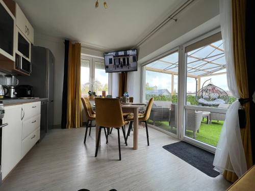 a kitchen and dining room with a table and a large window at Comfort Zone Ostróda Villa Apartment B in Ostróda
