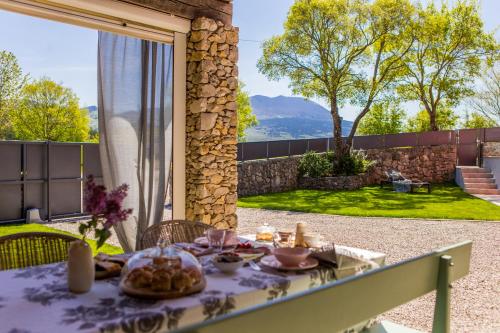 a table with food on it with a view of a garden at Villa Piano - Učka Nature Park in Lupoglav
