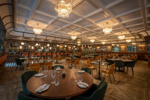 a restaurant with tables and chairs and chandeliers at The Samuel Hotel in Dublin