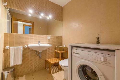 W łazience znajduje się pralka i umywalka. w obiekcie Tramontana 113 P1 w mieście Fornells