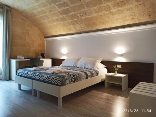 ein Schlafzimmer mit einem Bett und zwei Nachttischen in der Unterkunft In & Out Matera in Matera