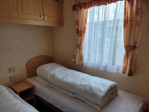 a small room with two beds and a window at 6 Berth Sealands Ingoldmells Free WIFI Westmorland SL in Ingoldmells