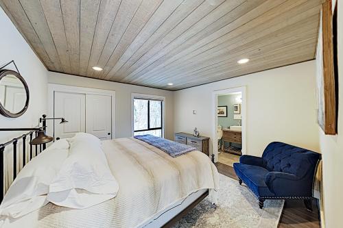 a bedroom with a large bed and a blue chair at Forest Pines Condo 1 - 46 in Incline Village