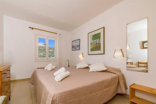 een slaapkamer met een bed met 2 kussens erop bij Tramontana 115 P1 in Fornells