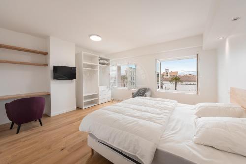 a white bedroom with a large bed and a window at AS21778- Magnifique P3 avec terrasse au cœur du Centre ville dans une maison de caractère in Le Grau-du-Roi