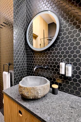 a bathroom with a stone sink and a mirror at Harda House Friends & Spa in Zakopane