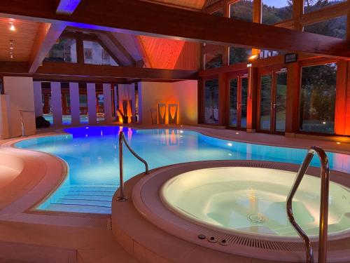 a large pool with a hot tub in a house at LE CLOS DES SOURCES Hôtel & Spa in Thannenkirch
