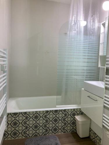 une salle de bain blanche avec une baignoire et un lavabo dans l'établissement Le Studio Victoria II -Mon Desert Village -27m2, à Nancy