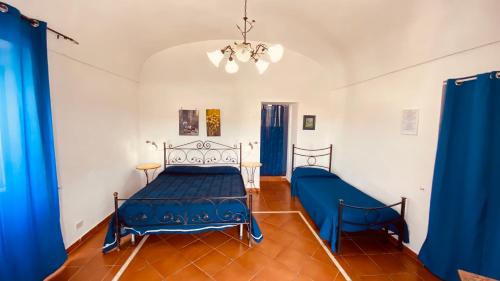 a bedroom with a blue bed and blue curtains at Casa Ninetta - Immobilevante in Ponza