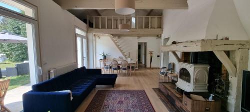 ein Wohnzimmer mit einem blauen Sofa und einem Kamin in der Unterkunft Jolie maison en pleine nature in Villiers-sous-Grez