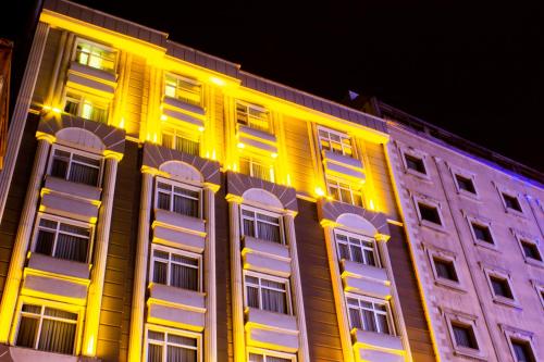 un bâtiment avec des fenêtres jaunes et blanches la nuit dans l'établissement Sumela Park Hotel, à Trabzon