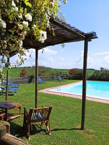 a wooden bench sitting next to a swimming pool at Podere Cartaio Bio Farm, private pool, AirC in San Rocco a Pilli