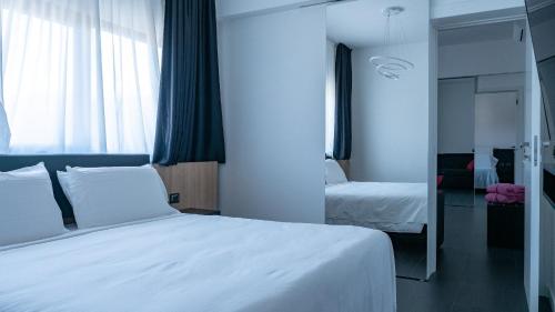 a bedroom with a white bed and a window at My Suite Hotel in LʼAquila