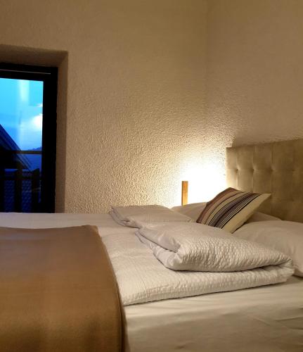 a bed with white sheets and pillows on it at bb26 apartment mountain Lozio in Lozio