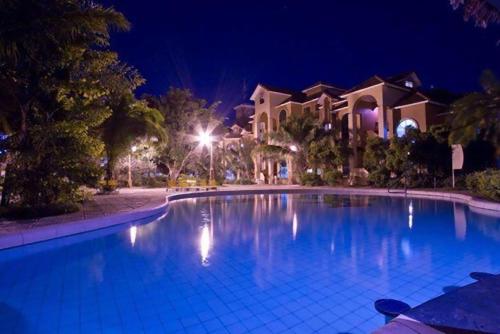 a large swimming pool in front of a house at night at Buganvillas Hotel Suites in Santa Cruz de la Sierra