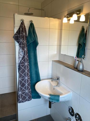 La salle de bains est pourvue d'un lavabo et d'un miroir. dans l'établissement Ferienwohnung Heeser Birkenhof - Urlaub auf dem Bauernhof mit Blick ins Grüne, à Weeze