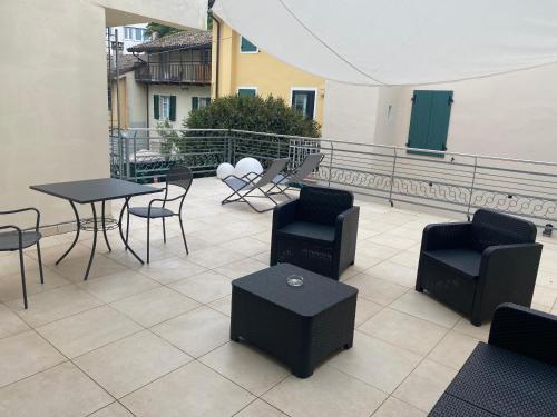 un patio con sillas, mesas y sillas en el balcón en Hotel Residence Ristorante Ramandolo, en Udine
