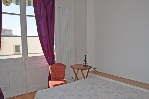 une chambre avec un lit, une chaise et une fenêtre dans l'établissement Palais Alexandre III, à Cannes