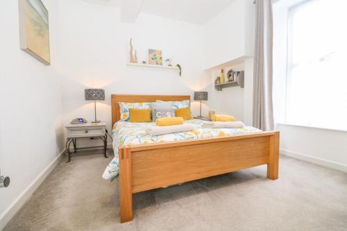 a bedroom with a wooden bed in a room at Sea Breeze in Marazion